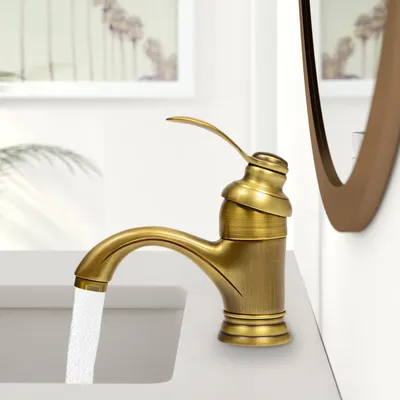 A close-up shot of a bronze-colored faucet with water running into a sink.