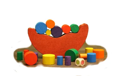A colorful wooden balance toy with various shaped blocks arranged on a rocking base and around it.