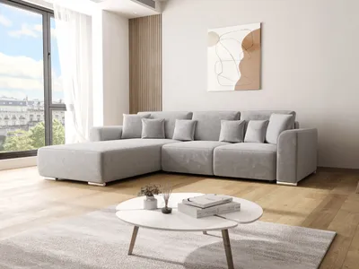 A modern living room with a large sectional sofa, a coffee table, and a large window with a view of buildings.