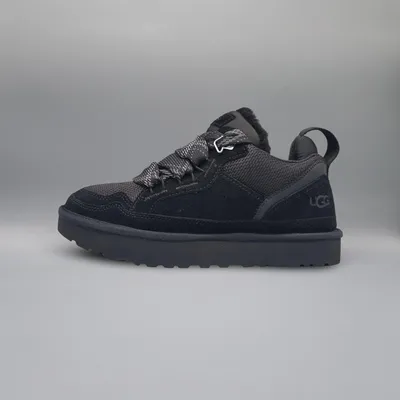 A black UGG boot is shown against a plain gray background.