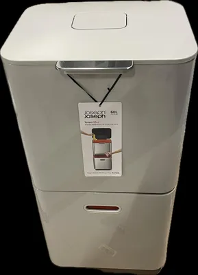 A tall, gray and white recycling bin with a tag hanging from the lid.