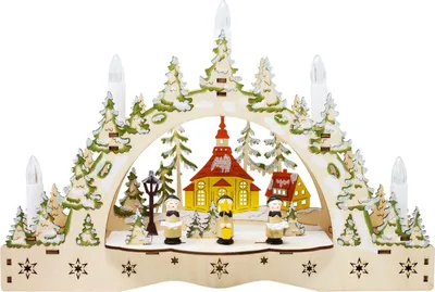 A wooden Christmas decoration with LED candles, depicting a winter village scene with a church and figures.