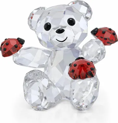 A clear, well-lit studio shot of a crystal teddy bear figurine holding ladybugs.