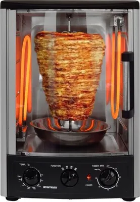 A mini oven with a rotating spit of meat inside, illuminated by orange heating elements.