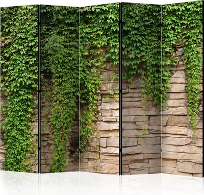 A room divider with a stone wall pattern covered in ivy.