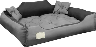 A dog bed with two small pillows.