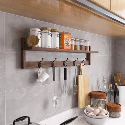 A kitchen shelf with various items like jars, spice containers, and kitchen utensils hanging on hooks.