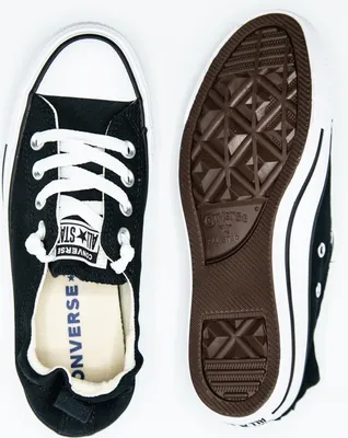 A top-down view of two black Converse sneakers, one showing the sole and the other the interior.