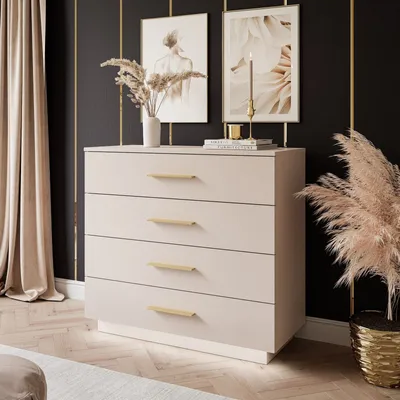 A modern bedroom setting with a beige dresser, decorative art, and plants.
