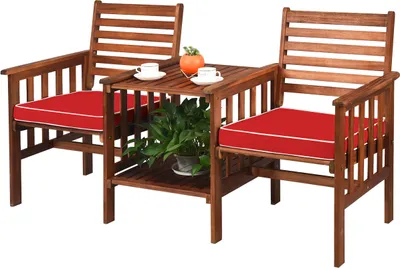 A wooden garden bench with red cushions and a small table with two cups and a plant.