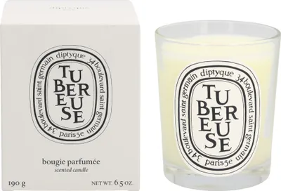 A scented candle and its packaging are displayed side-by-side against a white background.