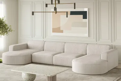 A modern living room with a large U-shaped sofa, a coffee table, and abstract art on the wall.