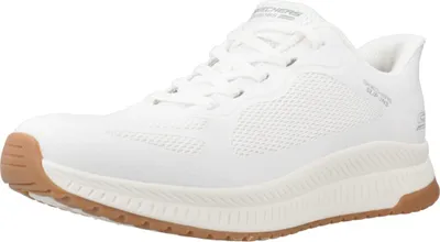 A white Skechers sneaker with a brown sole is shown against a white background.