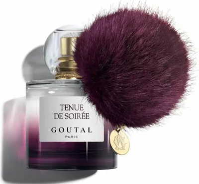 A bottle of perfume with a fluffy pom-pom attached.