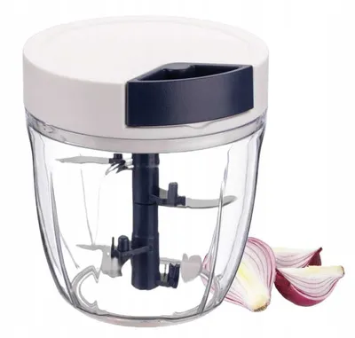 A manual food chopper with red onion slices next to it.