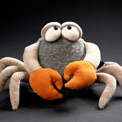 A stuffed toy crab against a black background.
