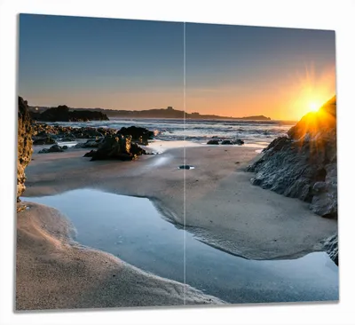 Produktbild von Wallario Herdabdeckplatte aus Glas, Größe 60 x 52 cm 2-teilig, Motiv Sonnenuntergang hinter einem Felsen am Strand