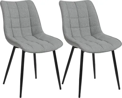 Two gray upholstered dining chairs with black metal legs are shown against a white background.