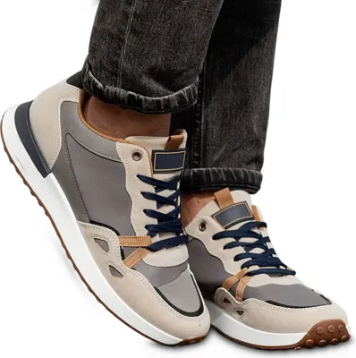 A pair of men's sneakers worn with dark jeans.