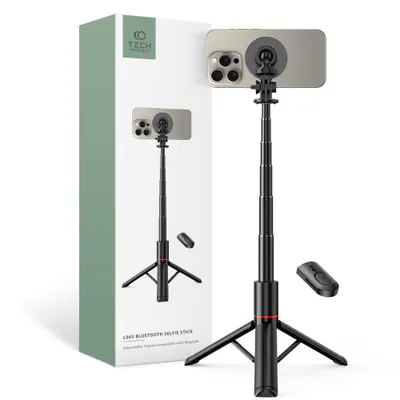 A product shot of a black selfie stick with a tripod base, a smartphone attached, and a remote control, next to its packaging.