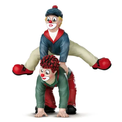 Two clown figurines are depicted in a playful pose, with one clown on the back of the other, simulating a 'bocksprung' or vault.