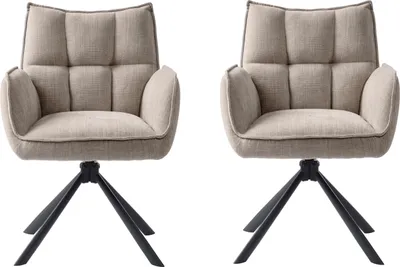 Two beige armchairs with black bases against a white background.