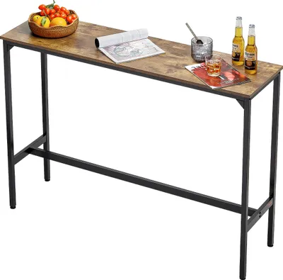 A long, narrow bar table with a wood-look top and black metal legs, set against a white background. There are some decorative items on the table.