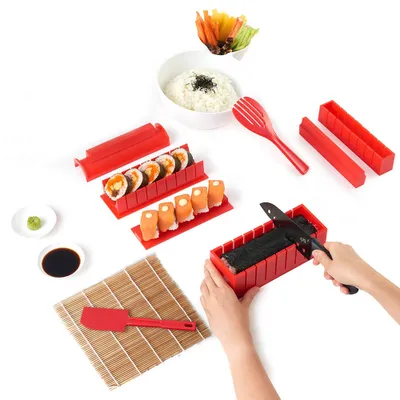 A sushi making kit is laid out on a white surface, with various components and finished sushi rolls visible.