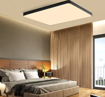 A modern bedroom with a bed, curtains, and a ceiling light.