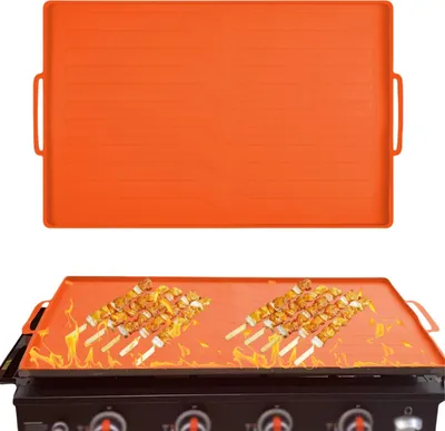 An orange silicone grill mat is shown on a grill with skewers of food, and another mat is shown above.