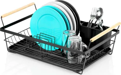 A black metal dish drying rack filled with plates, glasses, and cutlery, set against a white background.