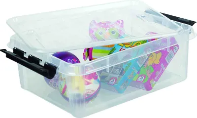 A clear plastic storage box with black latches, filled with various toys and items.