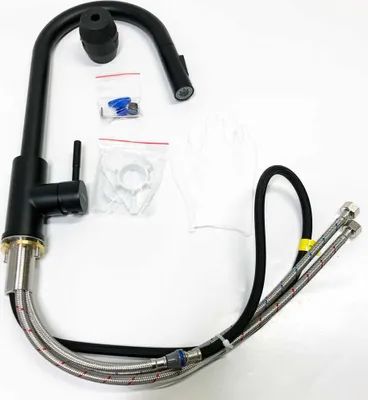 A black kitchen faucet with its accessories laid out on a white background.
