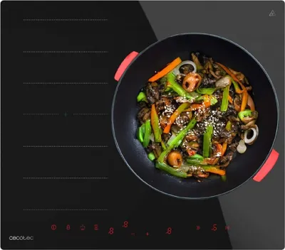 A close-up shot of a black induction cooktop with a wok full of stir-fried food placed on it.