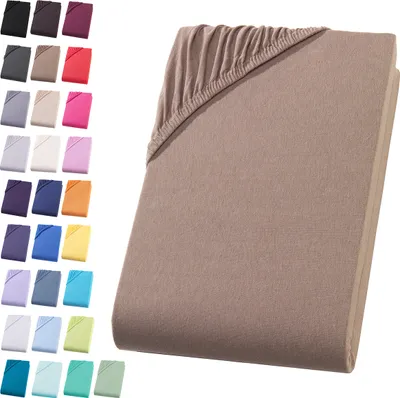 A collection of fabric swatches in various colors arranged on the left side of the image, with a folded fitted sheet in a nougat brown color occupying the right side.