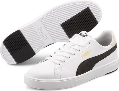 A pair of white Puma sneakers is shown from a slightly elevated angle, with one shoe in the foreground and the sole of the other shoe visible in the background.