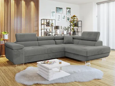 A modern living room with a sectional sofa, coffee table, and decorative shelves.