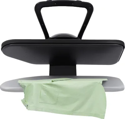 A close-up shot of a steam iron machine with a green shirt placed on the ironing board.