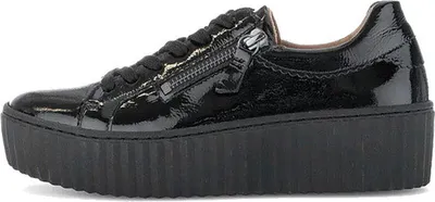 A single black patent leather sneaker with a platform sole and a zipper on the side, shown from the side view.