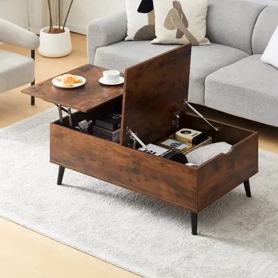 A wooden coffee table with its top lifted, revealing storage space, in a living room setting with a sofa and armchair.