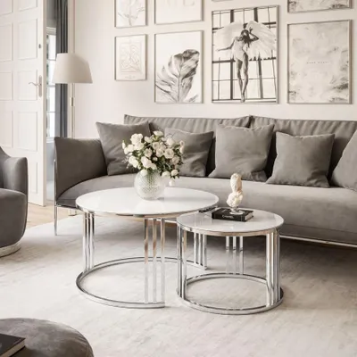 A living room scene with a sofa, coffee tables, and artwork.