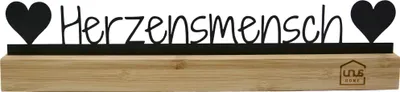 A decorative sign with the word "Herzensmensch" and two hearts, mounted on a wooden base.