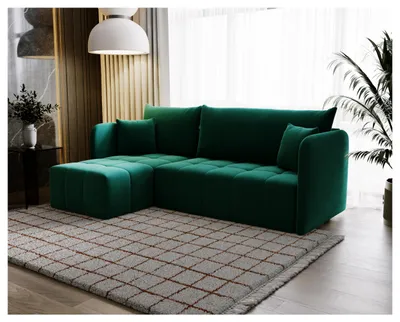 A green sectional sofa is placed on a rug in a living room setting.