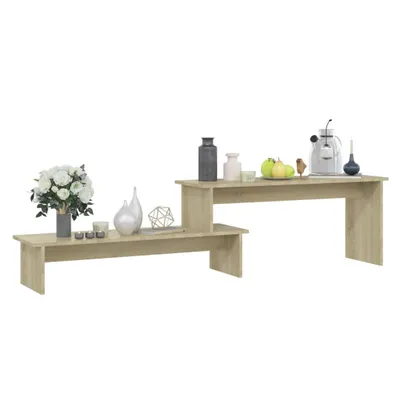 A set of two tiered coffee tables with various decorative items on them.