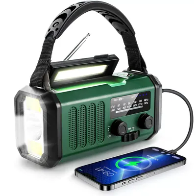 A green emergency radio with a flashlight and a phone charging from it.