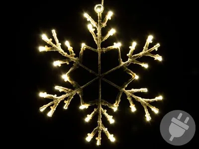 A lit snowflake decoration against a black background.