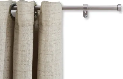 A close-up of a curtain rod with a beige curtain hanging from it.