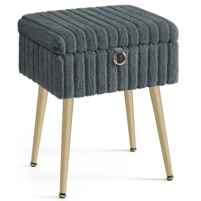 A gray upholstered stool with gold metal legs on a white background.