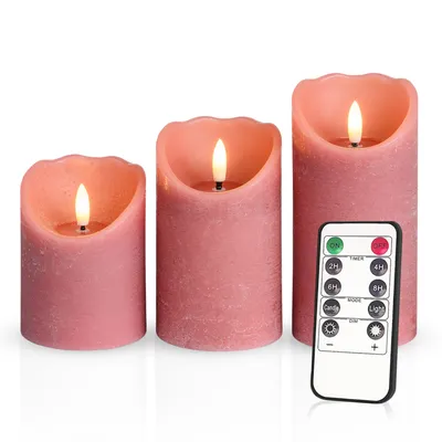 Three LED candles of varying heights are arranged on a white background, with a remote control placed in front of the rightmost candle.