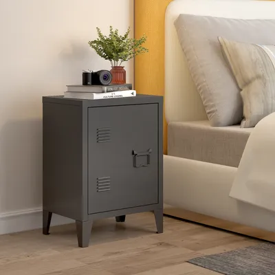 A dark gray metal nightstand with a single door and a handle is placed next to a bed with a yellow headboard and light gray bedding.